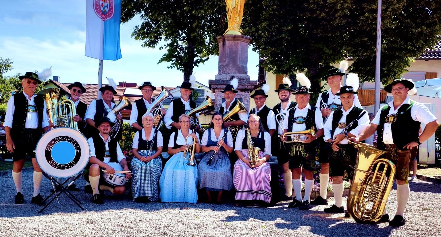 Gruppenbild der Blaskapelle Seefeld e.V. in Tracht vor der Mariensäule